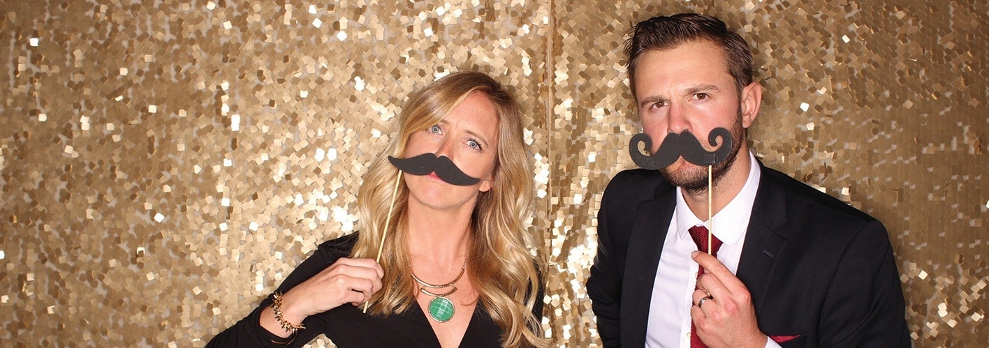 man and woman wearing fake moustaches at a party